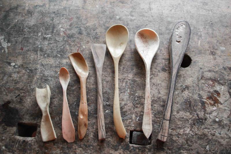 Sculpteur sur bois passionné dans son atelier, travaillant sur une chouette en bois