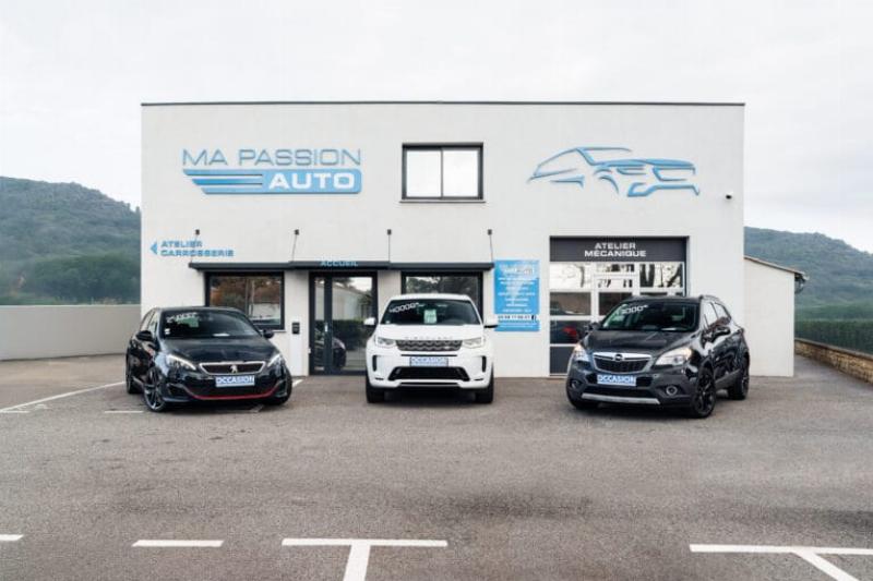 Un carrossier expert en débosselage sans peinture effectuant une finition méticuleuse sur une voiture de luxe