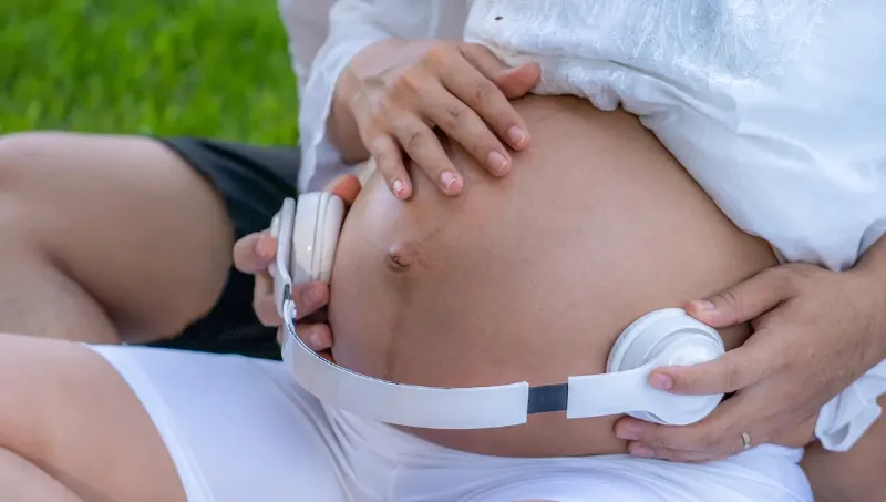 Une personne écoutant de la musique classique téléchargée avec un casque audio de haute qualité, dans un environnement paisible