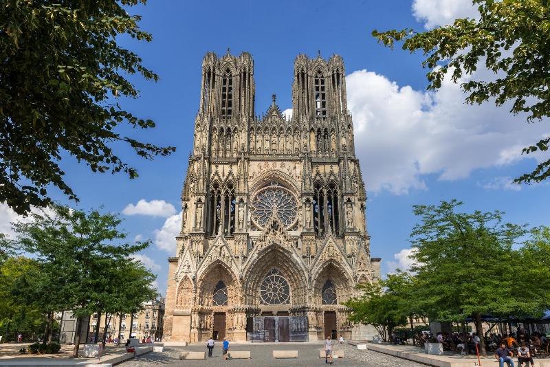 Façade majestueuse de la Cathédrale de Reims, célèbre pour son architecture gothique, ses rois sculptés et ses détails ornementaux, témoignant de l'histoire de France.