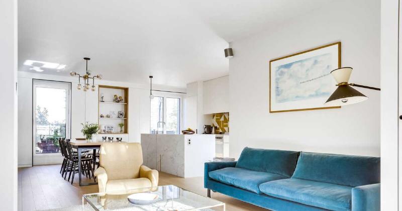 Une chaise longue Le Corbusier originale dans un salon moderne et lumineux, créant une ambiance élégante