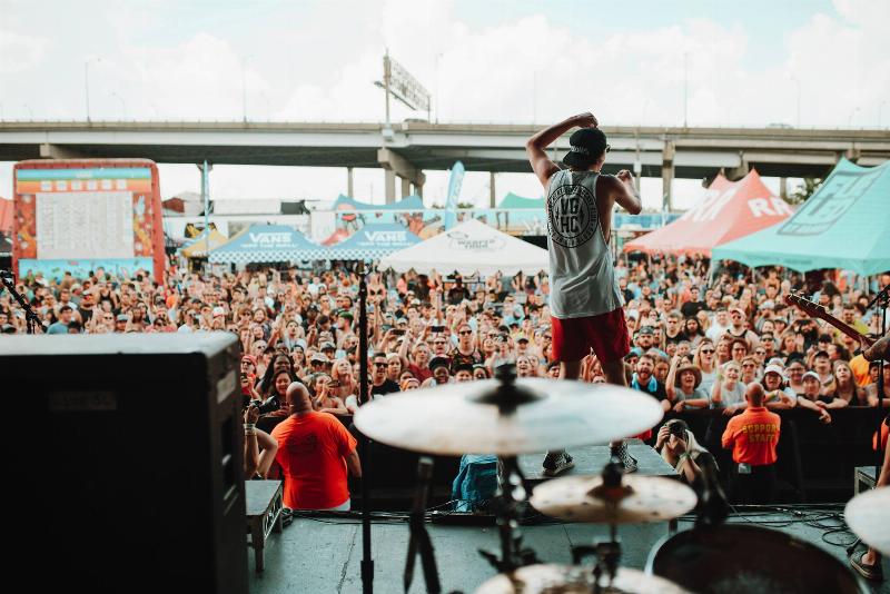 Un groupe d'amis français riant et chantant ensemble dans un café, avec une chanson populaire en arrière-plan.