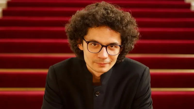 Un chef d'orchestre passionné dirigeant des musiciens interprétant un programme de musique classique française