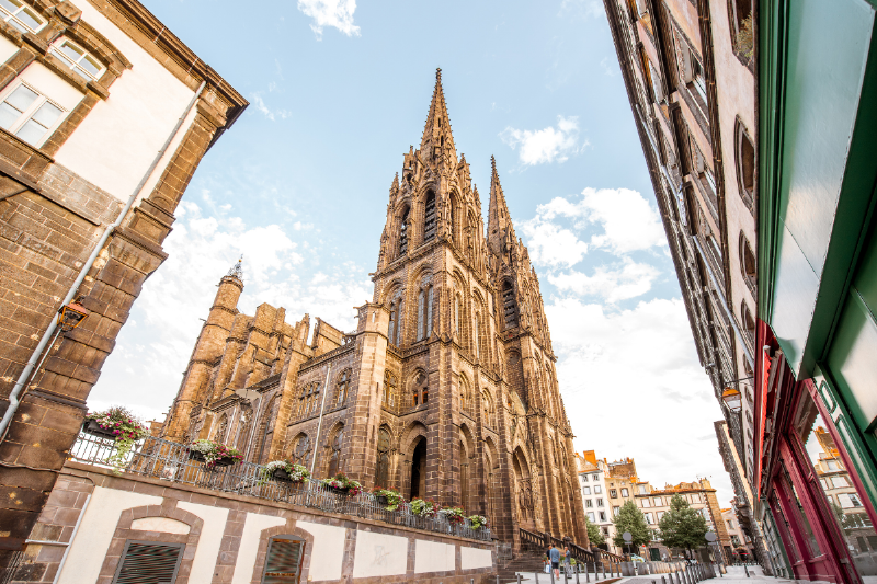 Façade d'un restaurant typique de Clermont-Ferrand dans une rue animée, invitant à découvrir où manger à Clermont-Ferrand.