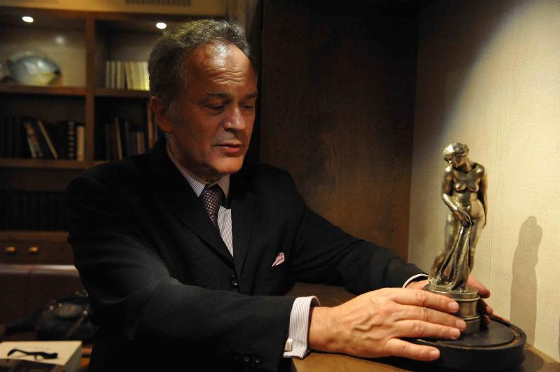 Un collectionneur expert examine un bronze de Rodin pour son prix et son authentification