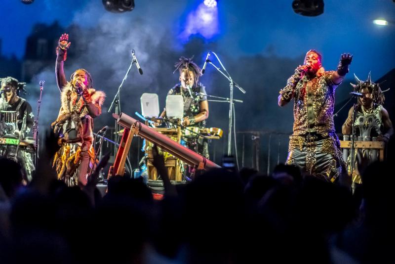 Ambiance d'un concert de chanson française en 2024, avec une foule captivée par l'artiste sur scène