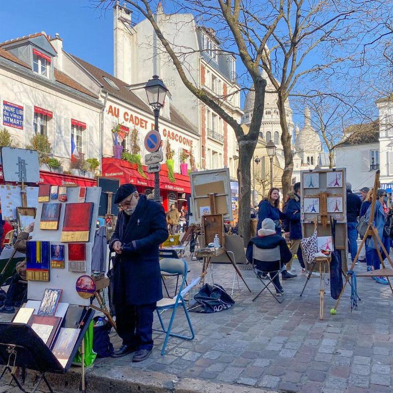 Artiste peignant un bouquet de fleurs dans un atelier lumineux, style français. 
