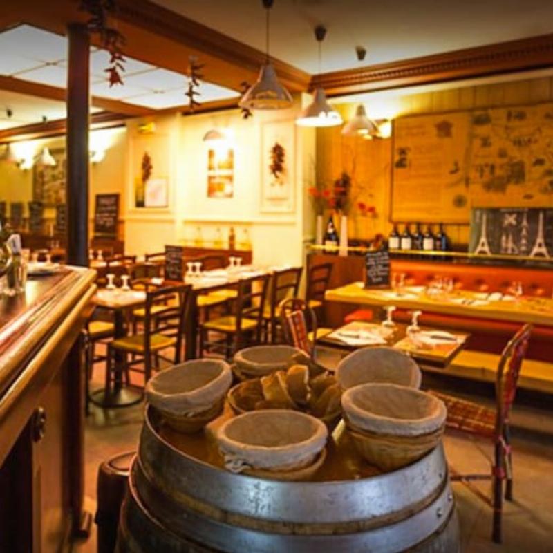 Une table française remplie de pain croustillant, fromages variés, et verre de vin, promouvant le partage