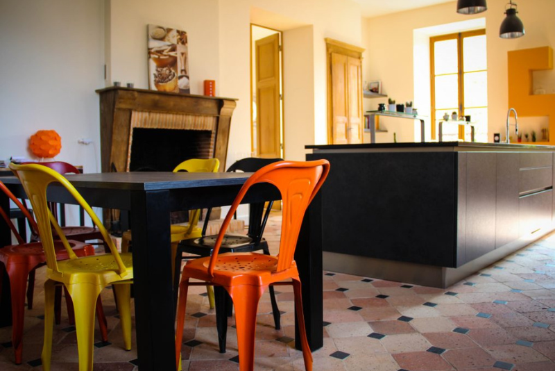 Une cuisine française au style chic et rétro avec des armoires vert menthe et des accents de laiton.