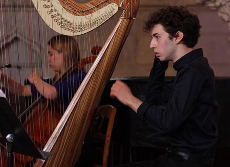 Partitions anciennes des œuvres de Debussy et Ravel sur un pupitre élégant lors d'un concert à Bruxelles 2024