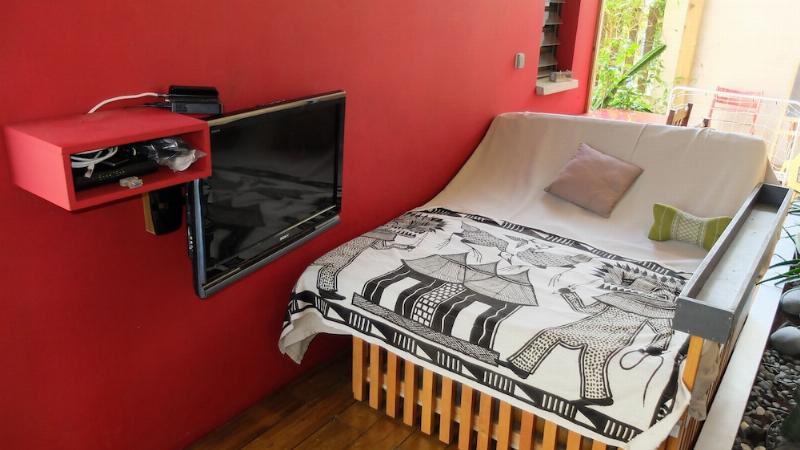 Une salle de bain balinaise moderne ouverte sur un jardin luxuriant avec baignoire en pierre