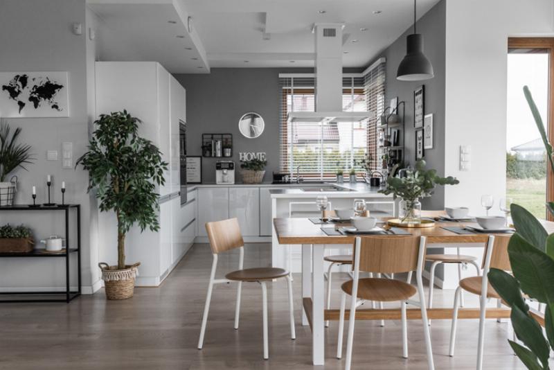 Un coin salon cosy et élégant, décoré dans un style français, avec un cadre en bois peint artistiquement exposé sur un mur de couleur douce, à côté d'une petite lampe vintage et d'un vase de fleurs.jpg