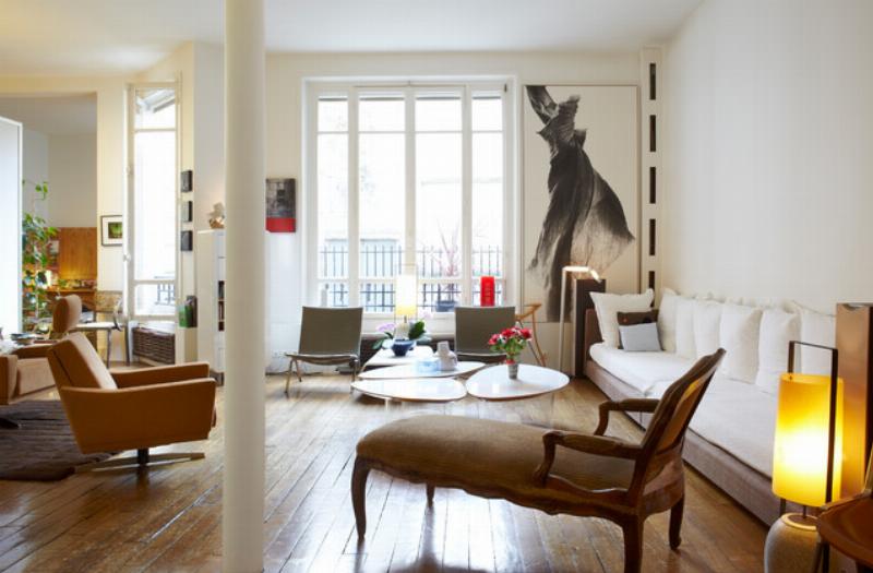 Design intérieur moderne français mélangeant un canapé contemporain avec des meubles antiques et des œuvres d'art