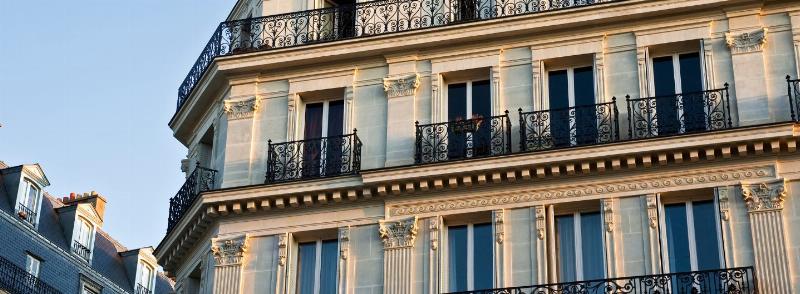 Détail architecture haussmannien parisien avec balcon en fer forgé et façade ornée