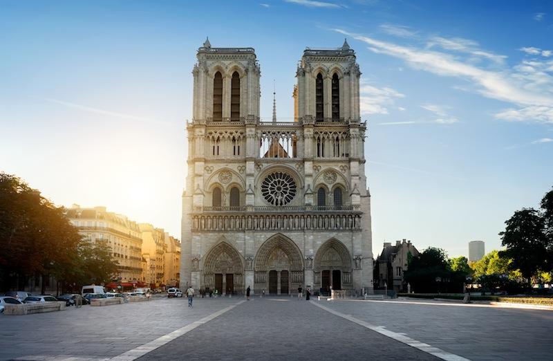 Vue panoramique de la cathédrale Notre-Dame de Paris restaurée avec des visiteurs devant l'entrée de l'exposition, mettant en avant la billetterie et l'histoire