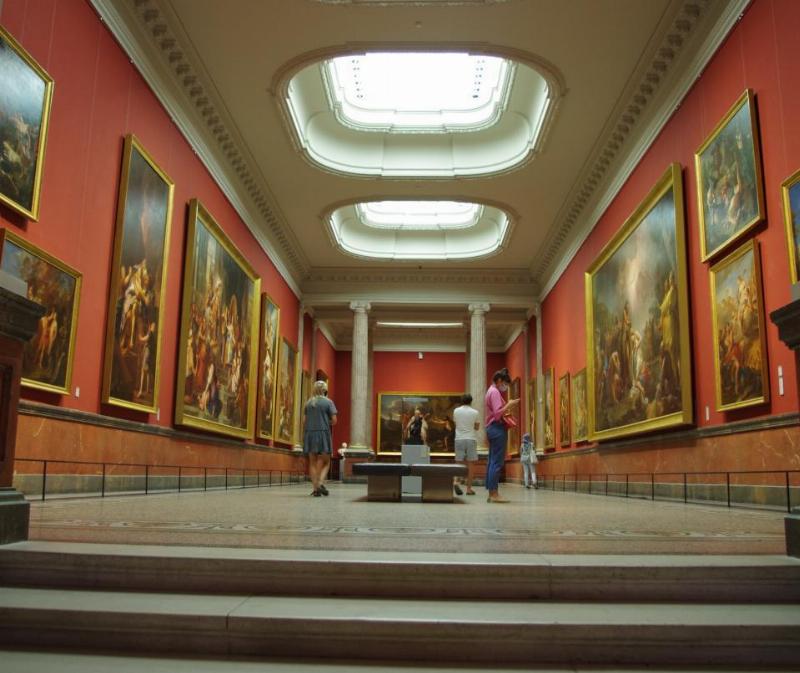 Une exposition d'œuvres pointillistes dans un musée français baigné de lumière naturelle