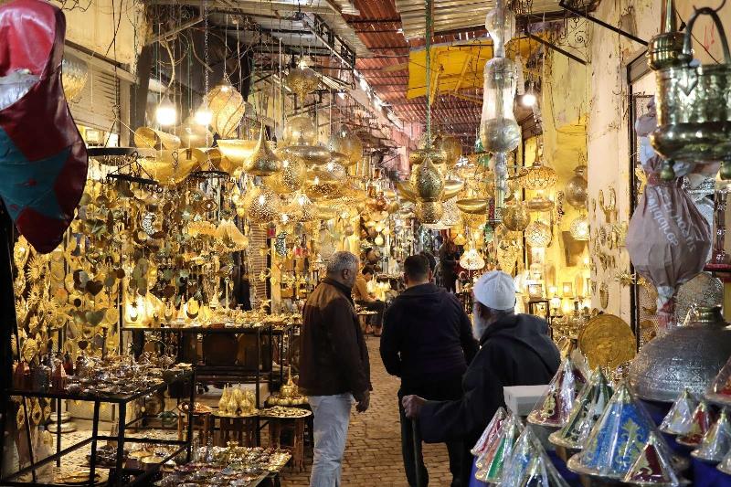 Un groupe de personnes dégustant des plats locaux dans un restaurant traditionnel d'Essaouira, avec une ambiance chaleureuse et des musiciens de fond, évoquant la richesse culturelle autour du Festival Musique Classique Essaouira.