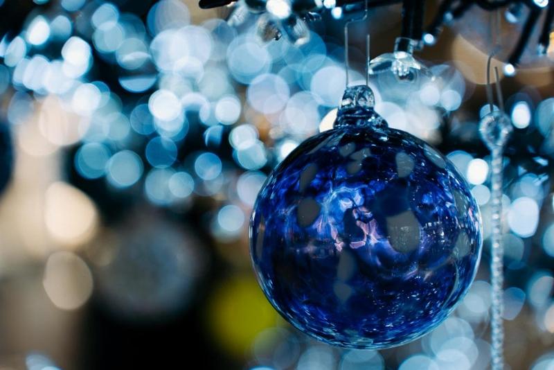 Marché de Noël animé avec des étals illuminés, des familles se promenant et des produits artisanaux