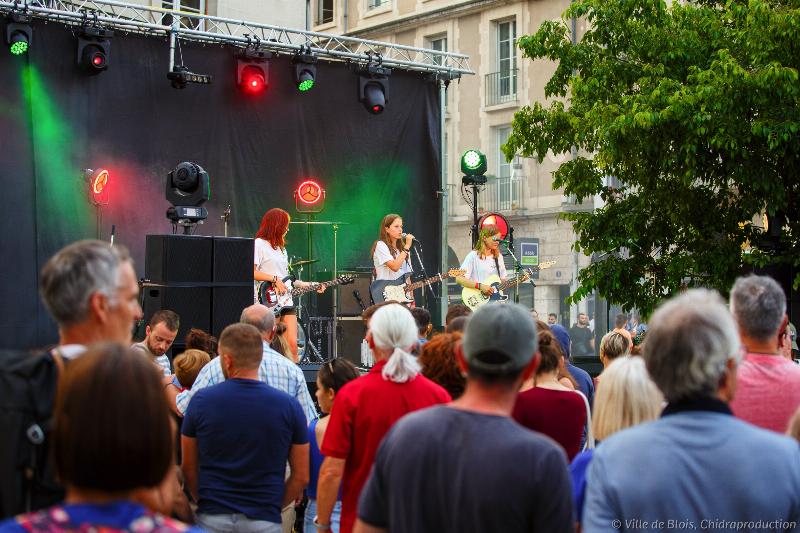 Scène de la Fête de la Musique en France, avec des gens qui chantent et dansent dans la rue