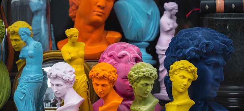 Mains appliquant une patine sur une sculpture en argile