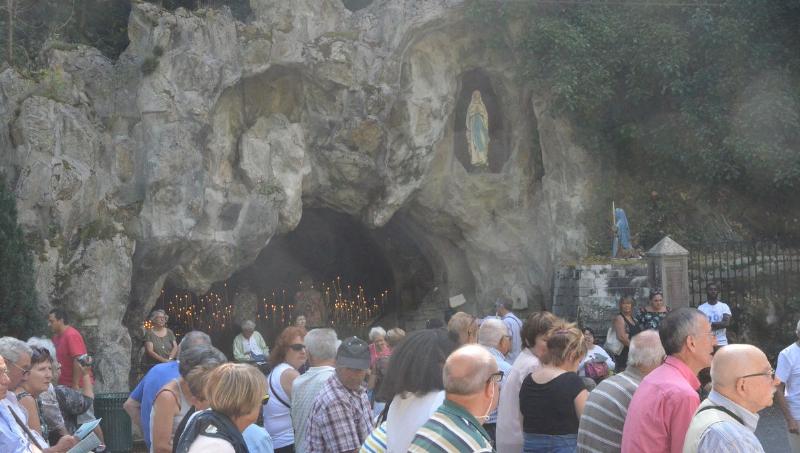 Foule de fidèles assistant à la messe de l'Assomption dans un sanctuaire marial en France.