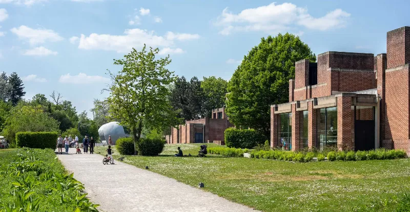 Une galerie d'art moderne présentant des personnages en papier mâché de différentes tailles.