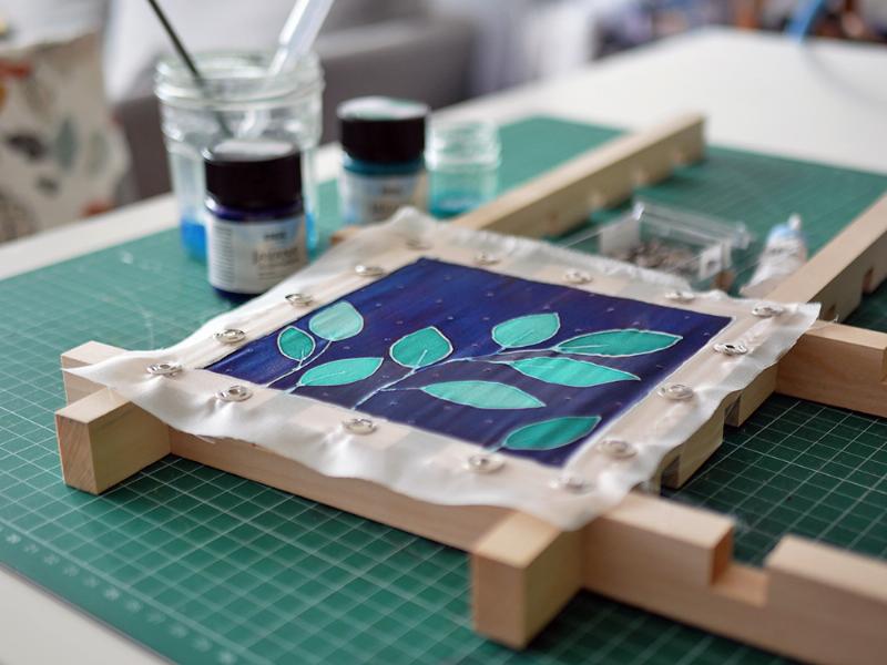 Artiste utilisant la gutta pour dessiner sur de la soie, style français