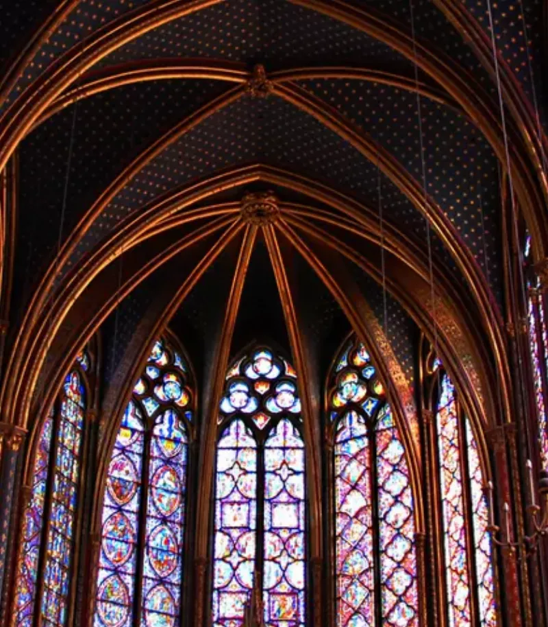Intérieur d'une cathédrale française, lumière traversant les vitraux, architecture majestueuse