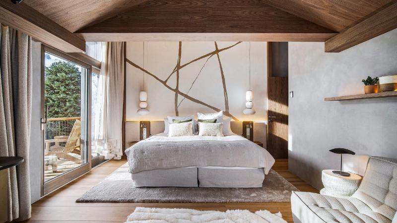Intérieur d'un chalet alpin moderne avec cheminée et vue montagne
