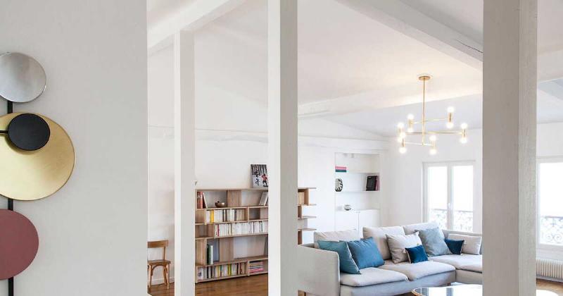 Un salon parisien élégant dominé par le blanc peinture, baigné de lumière naturelle.