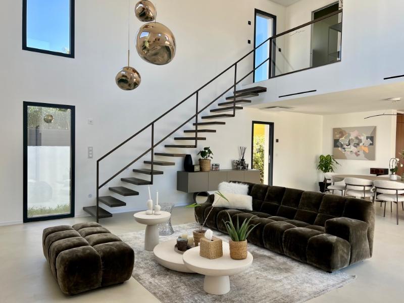 Intérieur minimaliste d'une maison d'architecture moderne française, baigné de lumière naturelle avec mobilier design