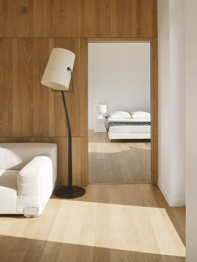 Intérieur paisible avec murs gris clair, mobilier épuré et lumière naturelle abondante