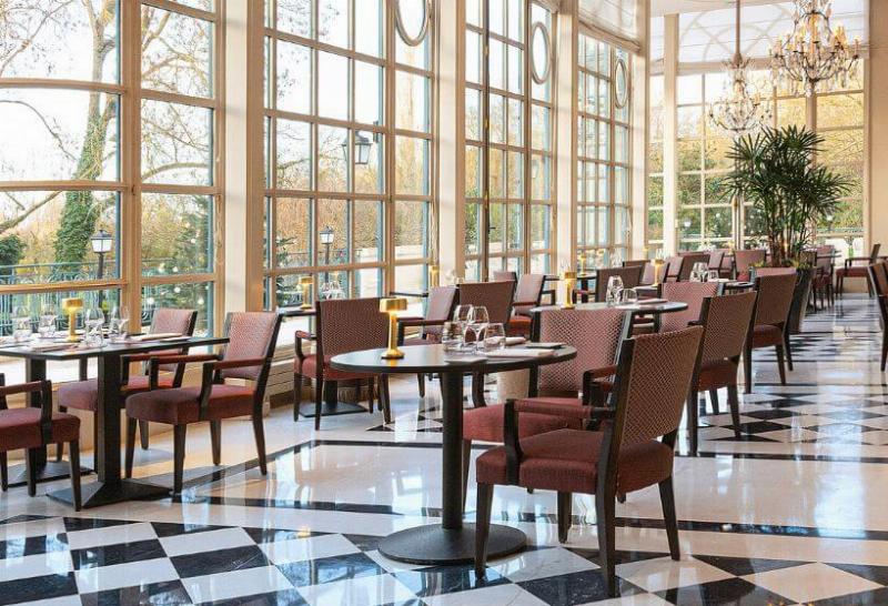 Intérieur d'un restaurant avec une vue imprenable sur les jardins de Versailles