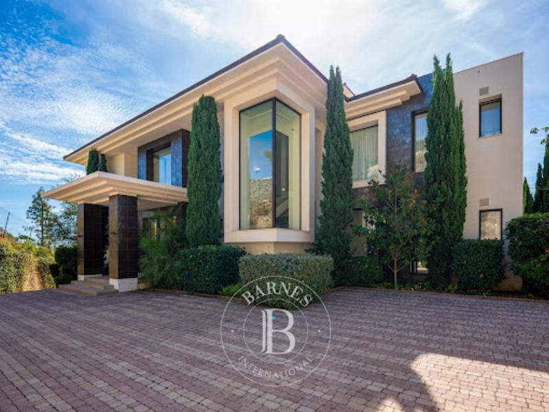 Un salon spacieux de villa moderne avec un mélange de mobilier contemporain et d'éléments d'art français, accentuant l'architecture interieur villa moderne