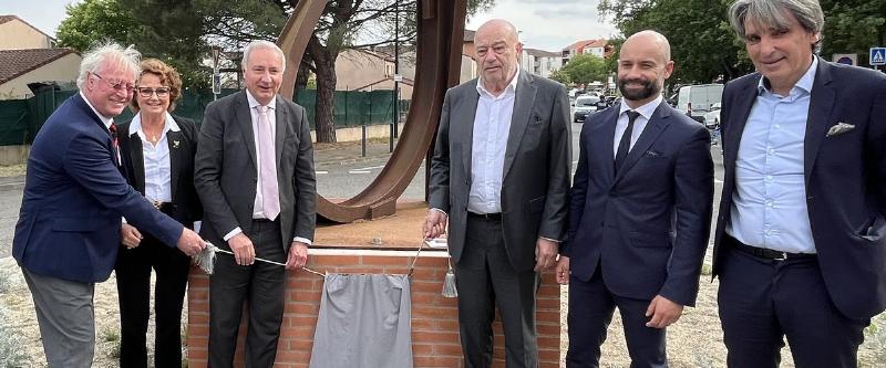 Une grande sculpture en acier de Jean-Pierre Rives, avec un bâtiment historique français en arrière-plan.