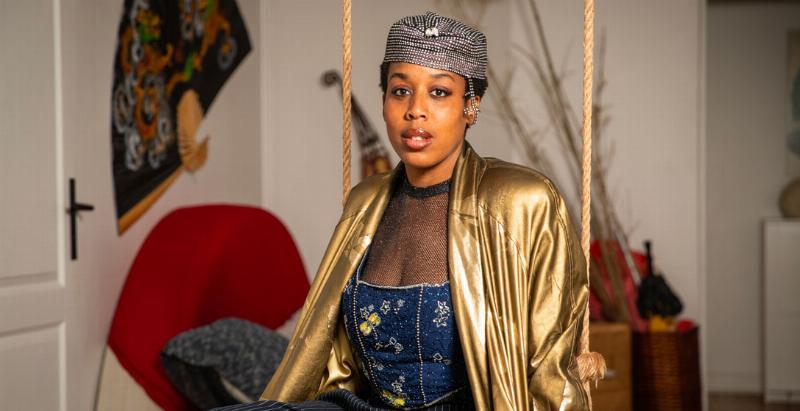 Jeune artiste chantant des chansons françaises, innovation musicale, scène futuriste, public