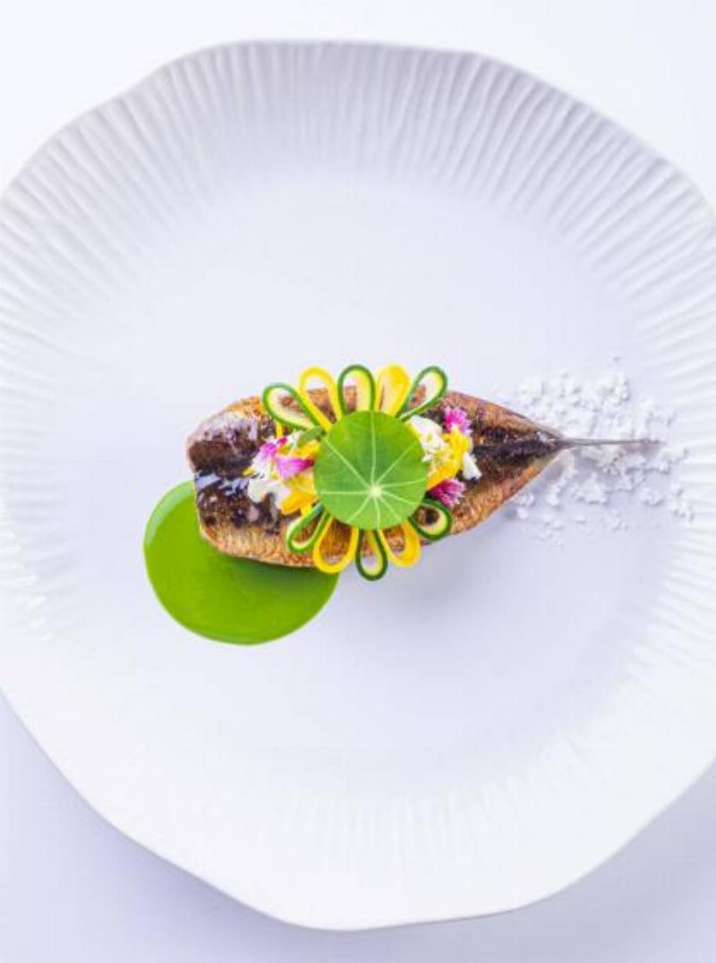 Une femme chic savourant un café en terrasse parisienne, incarnant l'élégance décontractée du lard de vivre.