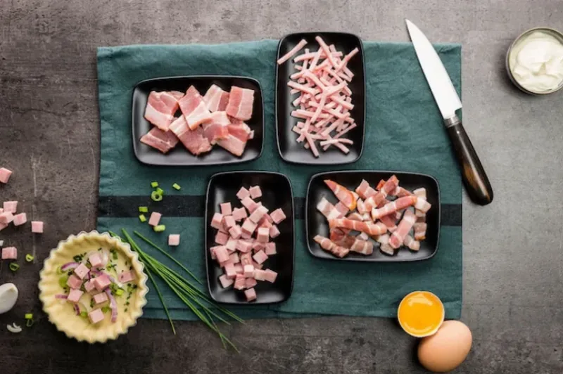 Des lardons dorés et croustillants dans une poêle, prêts à être ajoutés à un plat maison français