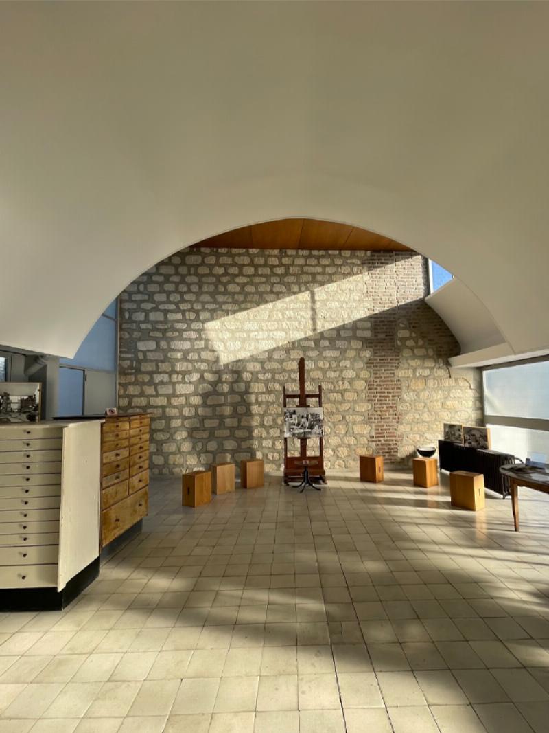 Le Corbusier dans son atelier avec un fauteuil design moderniste parisien et des croquis