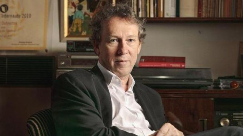 Un lecteur passionné lisant Le Figaro avec un livre du Goncourt, dans un café parisien, pour le Goncourt Le Figaro