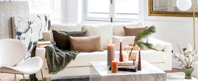 Une élégante table basse avec des livres Taschen sur l'architecture moderne, une tasse de thé et des fleurs fraîches dans un intérieur au style français.