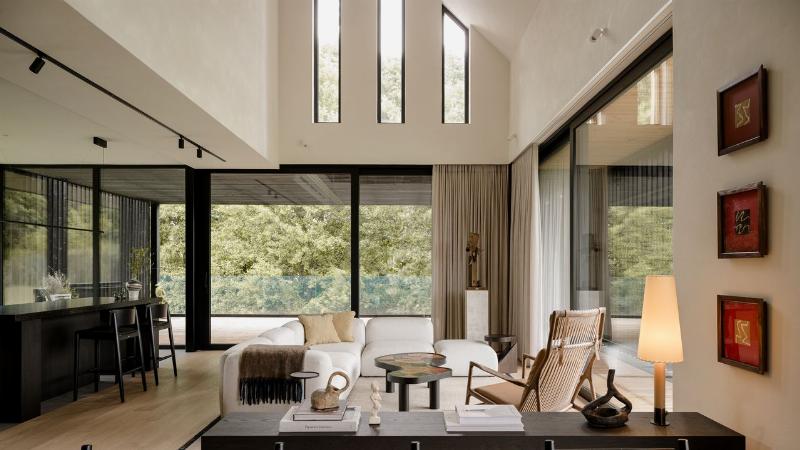 Maison moderne en bois clair dans un paysage de campagne française, architecture minimaliste