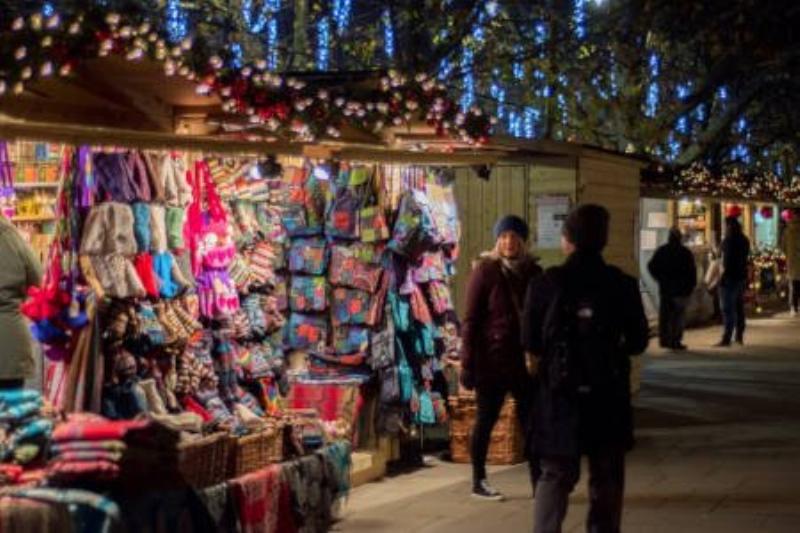 Ambiance de marché de Noël en France avec stands illuminés et foule joyeuse
