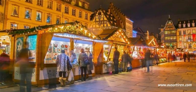 Marché de Noël animé en France, avec des chalets en bois éclairés, des décorations scintillantes et des passants profitant de l'ambiance hivernale.