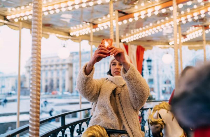 Marché de Noël français avec chalets décorés, lumières scintillantes et foule joyeuse