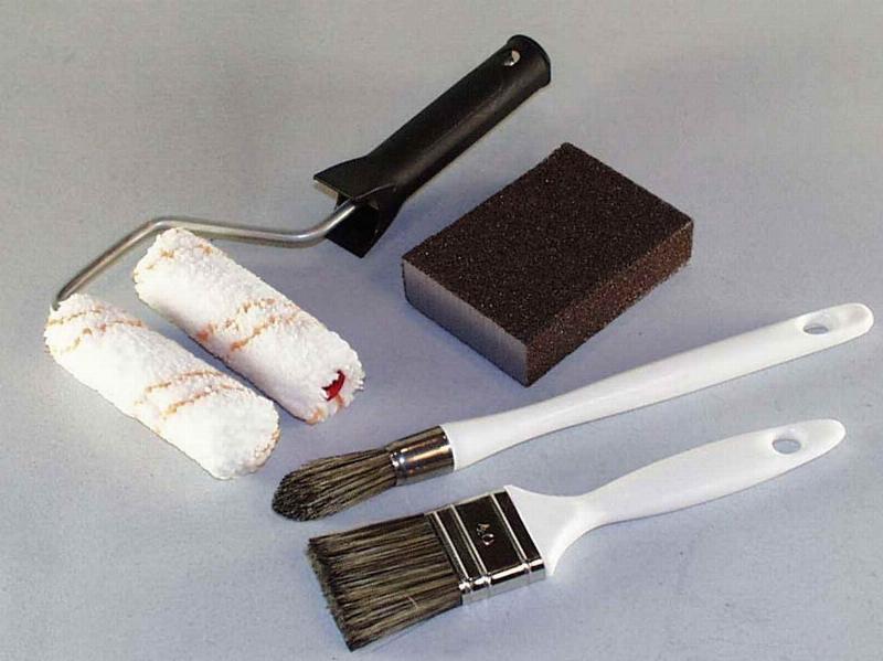 Gros plan sur les outils de qualité pour appliquer le blanc peinture avec précision.