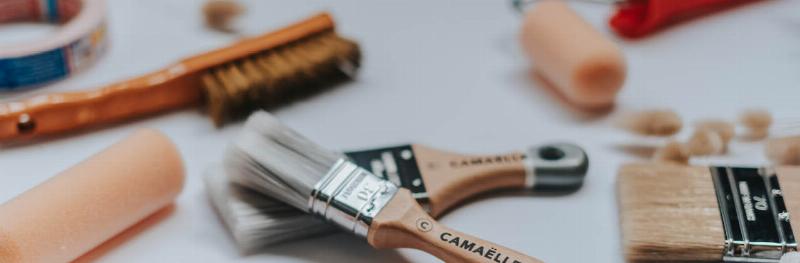 Matériel essentiel pour une peinture de salon moderne réussie avec pinceaux, rouleaux et ruban de masquage