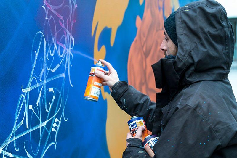 Vue détaillée du matériel essentiel pour la projection peinture utilisé par un artiste français, bombes de couleurs variées