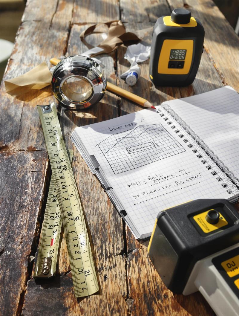 Homme mesurant mur mètre ruban calcul peinture m2 précis