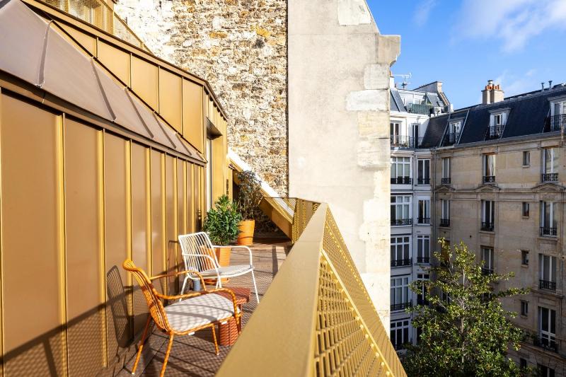 Notre-Dame de Paris illuminée, vue depuis un café en terrasse sur le quai avec un couple